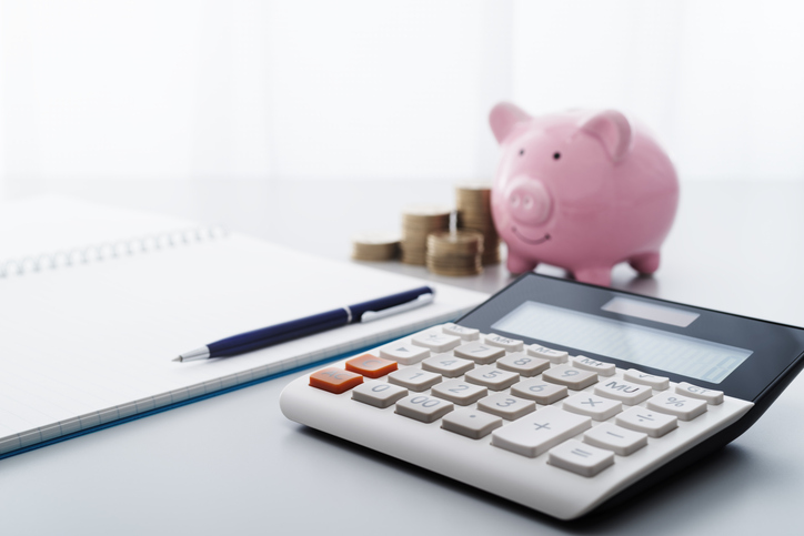 piggy bank, coins, paperwork, and calculator